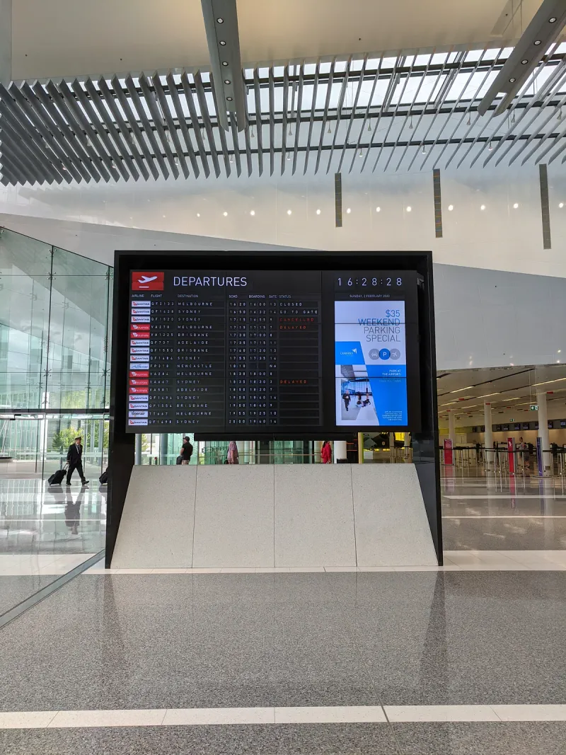 Airport departures board in a modern terminal listing flights by time, airline and gate