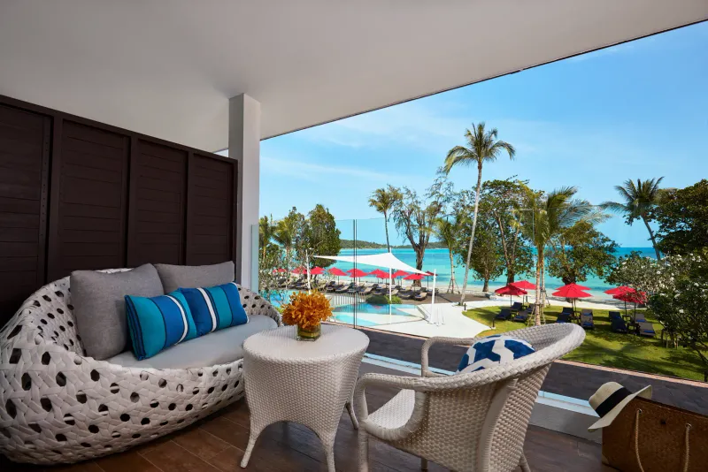 Amari Koh Samui room terrace with a woven lounge chair looking over the pool toward Chaweng Beach