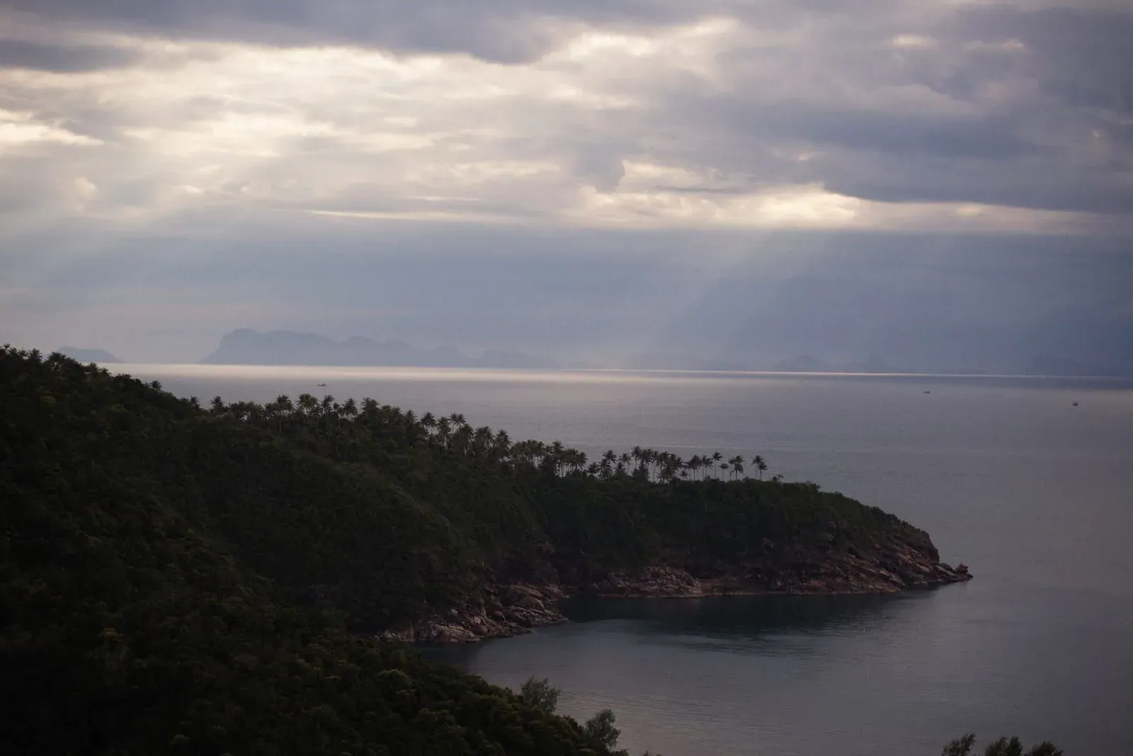 Evening light over a forested headland and the Gulf of Thailand