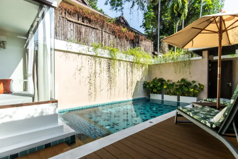 Private plunge pool with a sun lounger and umbrella in a Bandara Resort Samui villa courtyard