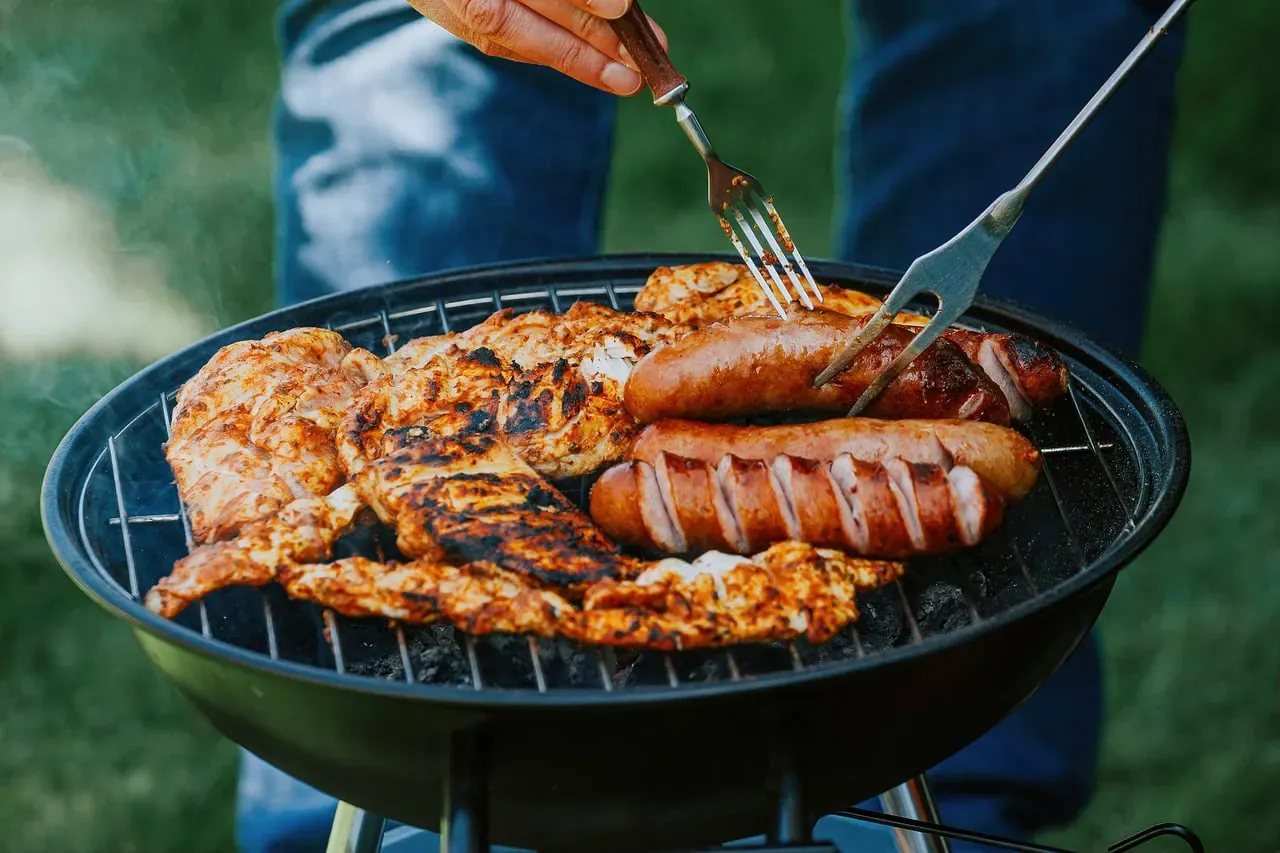 Sausages and chicken grilling on a barbecue