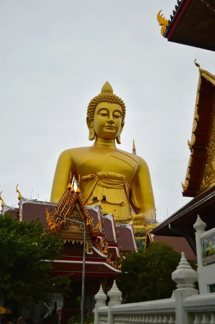 The Big Buddha's head and shoulders rising above the temple's red-tiled roofline