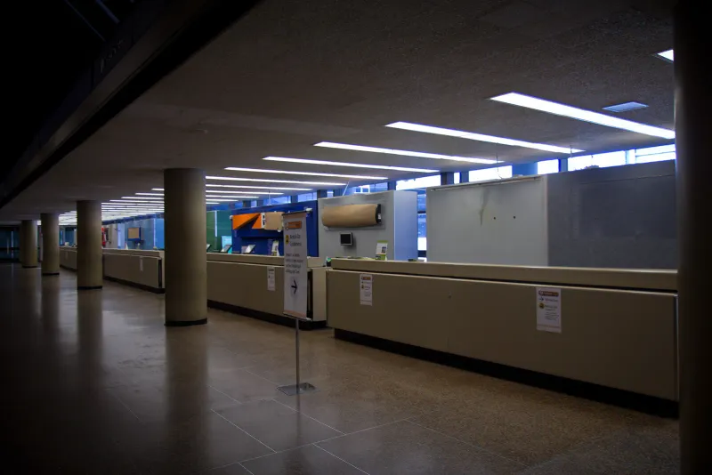 Empty airport car rental counter hall with the lights dimmed after hours