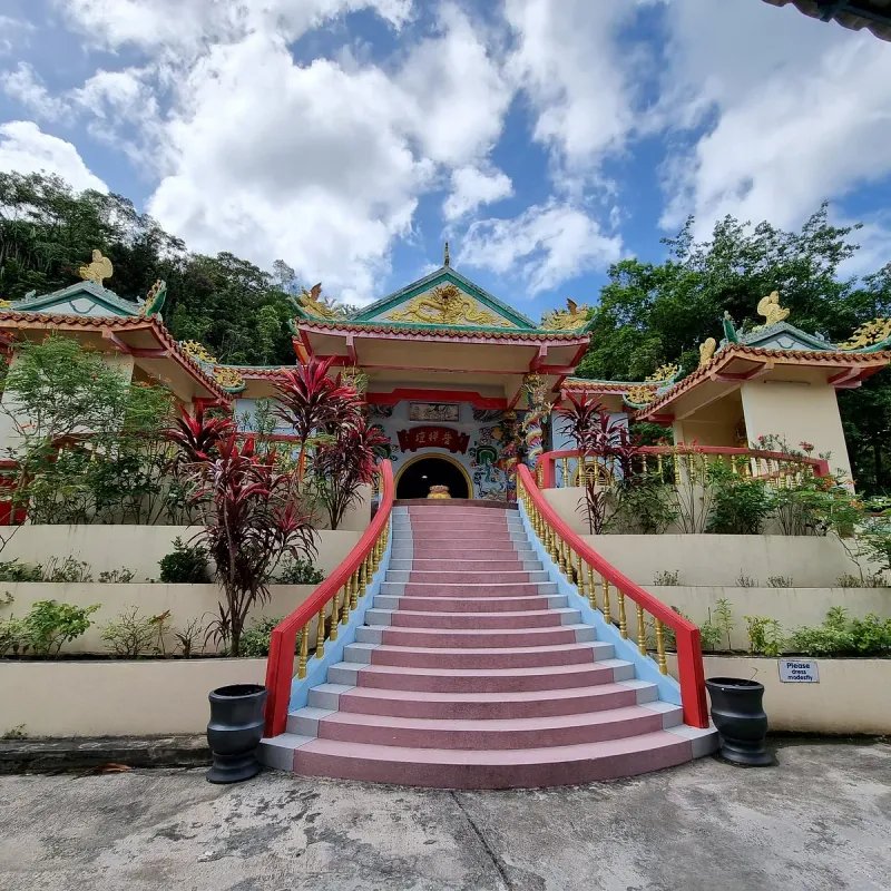 Pink stone staircase leading up to the red-and-gold entrance of the Guam Im Shrine