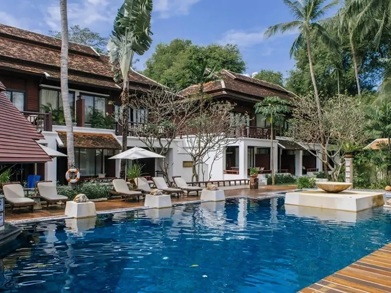 Pool with sunbeds in front of two-storey wooden guest buildings at Chaweng Regent Beach Resort