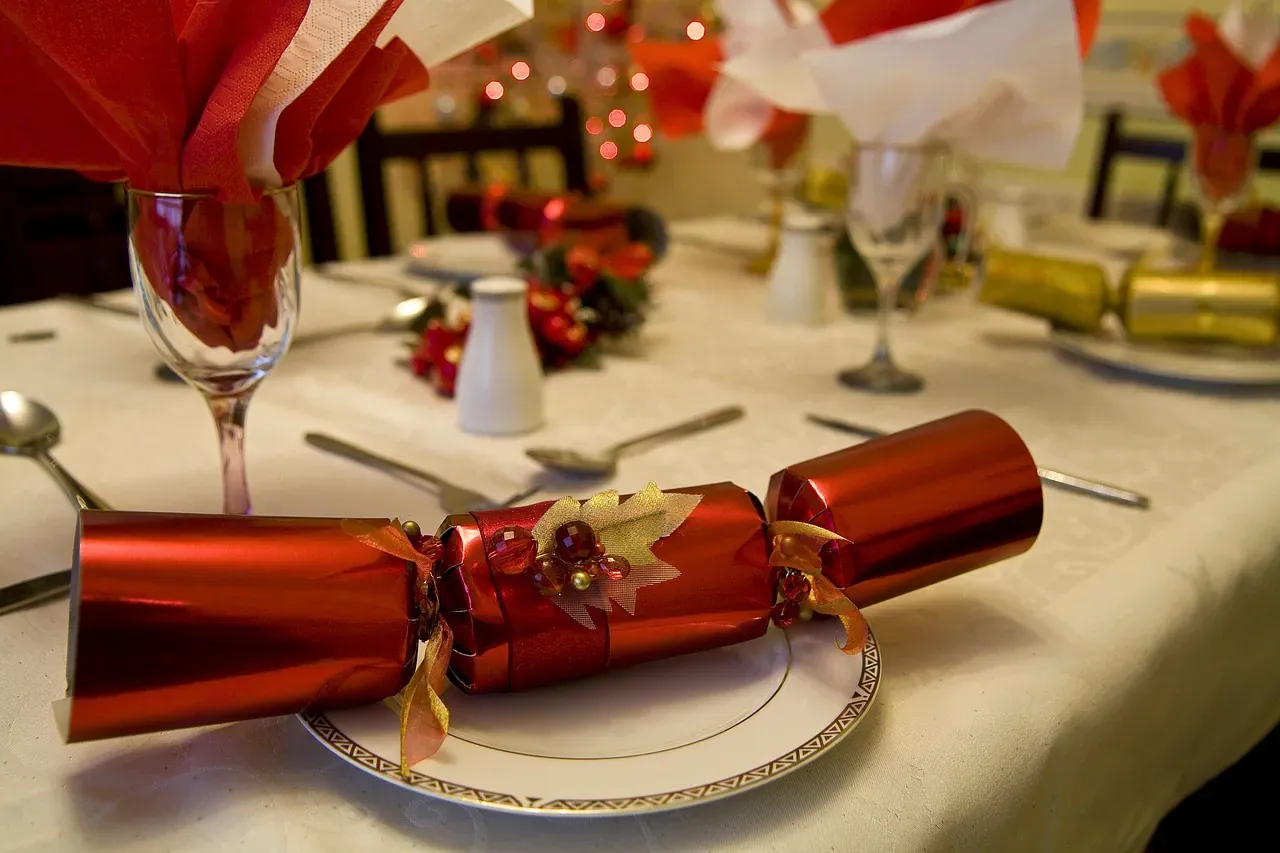 Christmas table with a red cracker and wine glasses