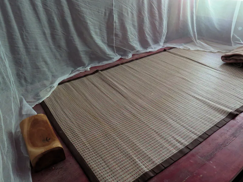 A simple sleeping mat and mosquito net inside one of the hermitage's retreat rooms