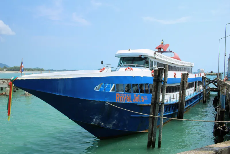 Blue and white passenger boat moored beside a pier with turquoise water on the Gulf coast