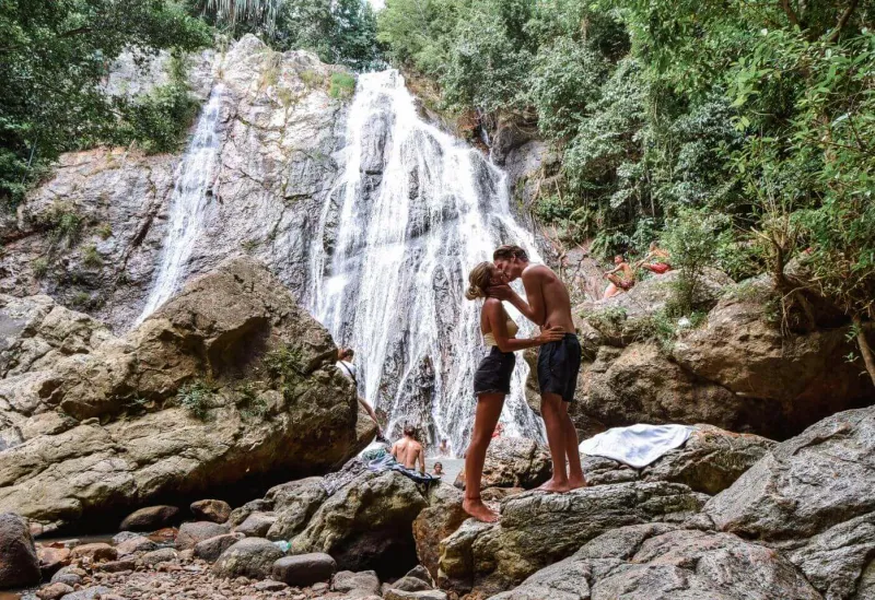 Visitors resting on the rocks around Hin Lad's main swimming pool