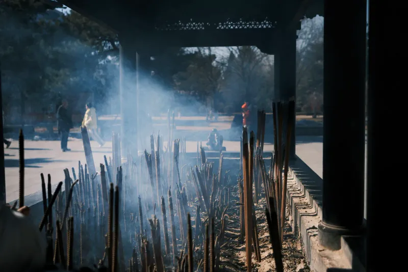 Morning light through incense smoke in a temple courtyard