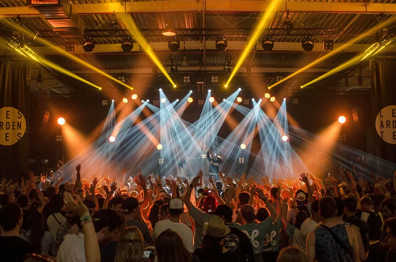 Live band on a lit stage in front of a crowd