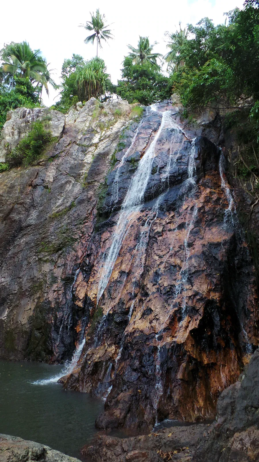 Tiered pools at Khun Si Waterfall surrounded by granite slabs