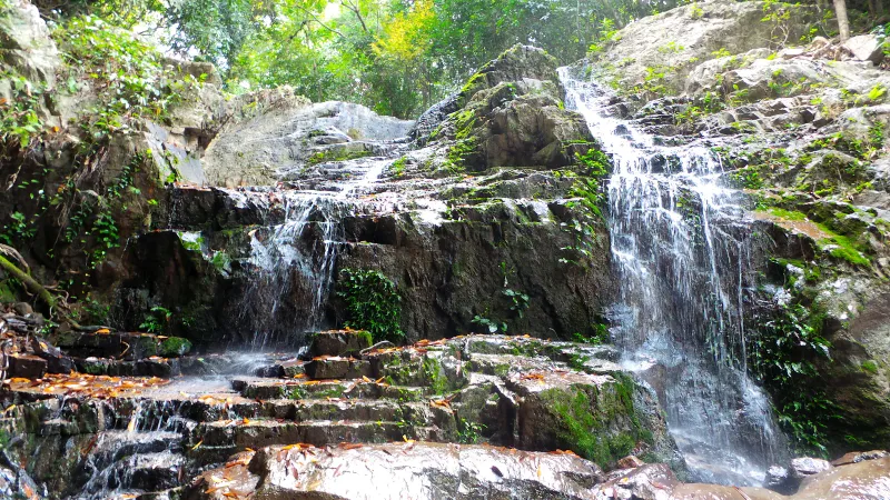 Khun Si Waterfall cascading over granite boulders in the jungle