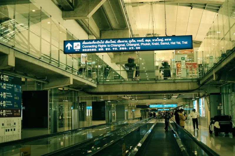 Airport terminal interior with moving walkway near the taxi and minibus counters