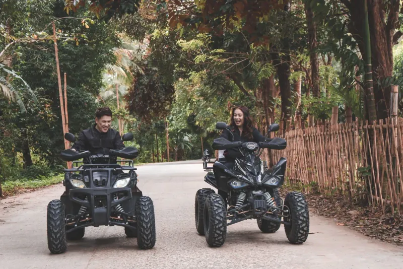 Two riders on quad bikes crossing rural terrain on a Koh Samui-style ATV adventure tour
