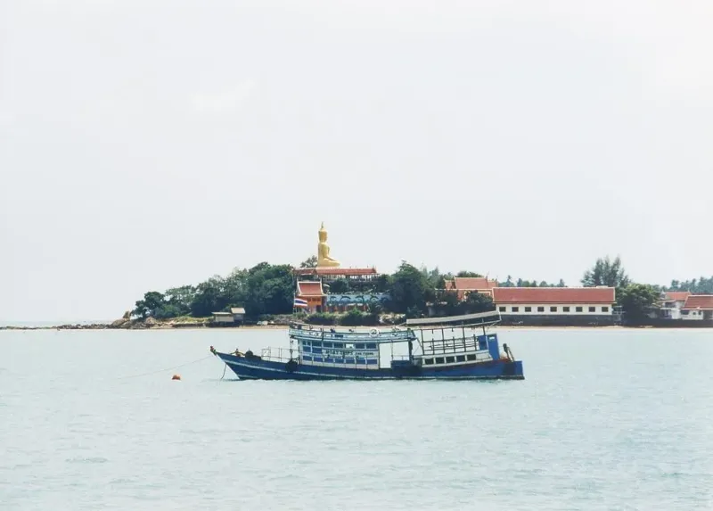 Golden Big Buddha statue at Wat Phra Yai temple on Koh Samui viewed from the causeway