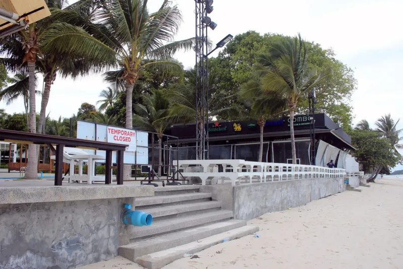 Beachfront beach club building on Chaweng Beach Koh Samui with palm trees and empty loungers