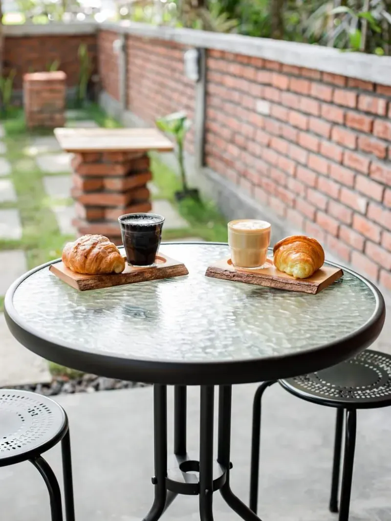 Coffee and croissants on a glass table at an outdoor cafe, typical of Fisherman's Village brunch spots