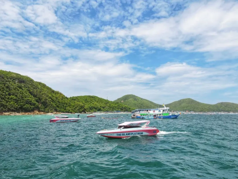 Colorful speedboats cruising past lush island hills used for Koh Samui island hopping tours