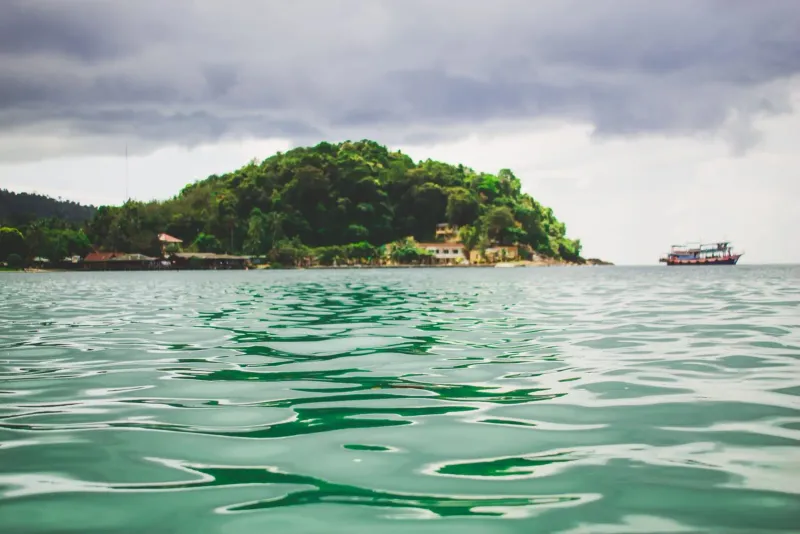 Lush tropical island surrounded by clear green water on a Koh Samui boat tour