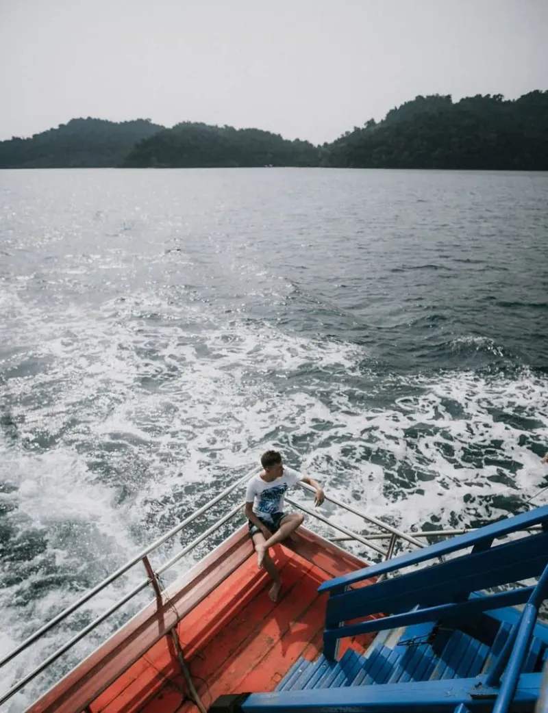 Traveler relaxing on a ferry deck with ocean views crossing between Gulf of Thailand islands