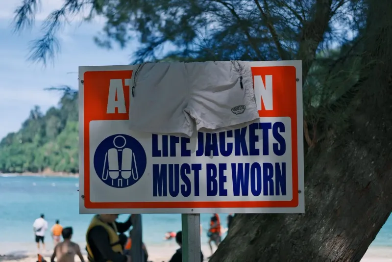 Life jacket and safety warning sign posted at a Thailand beachside location