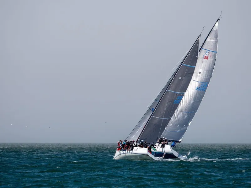 Sailing crew racing a yacht under a grey sky, typical of a Samui Regatta race day