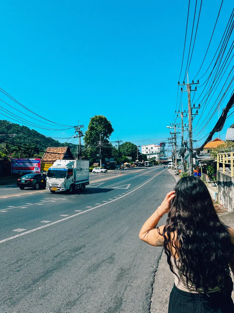 Traveller standing at the roadside on Koh Samui waiting for a ride along a quiet main road