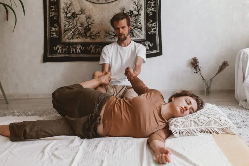 Woman receiving an assisted stretch during traditional Thai massage on Koh Samui