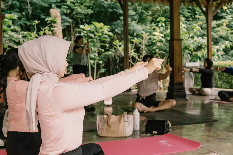 Group of women practicing yoga together in a serene open-air pavilion on Koh Samui