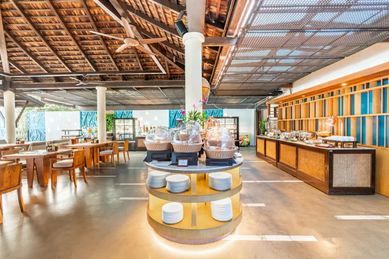 Open-air restaurant with a buffet counter and timber-beam roof at Melati Beach Resort