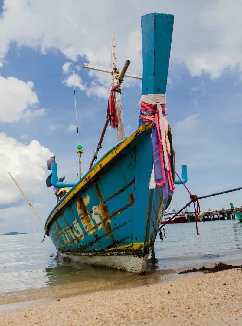 A painted fishing boat pulled up on the sand