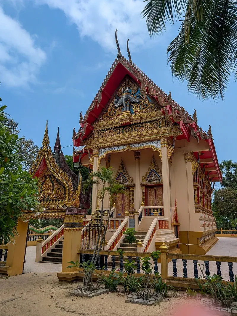 Wat Na Phra Lan's red-and-gold temple hall beside the beach