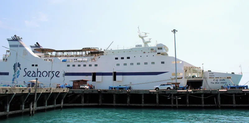 Large white Seahorse cruise ferry docked at a concrete pier under a pale sky