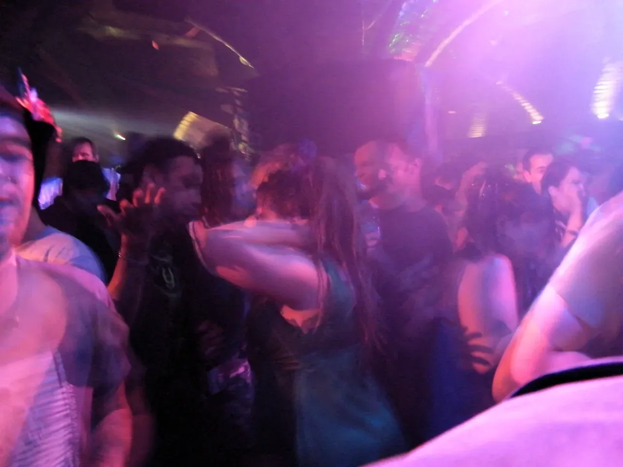 Crowd dancing under purple lights