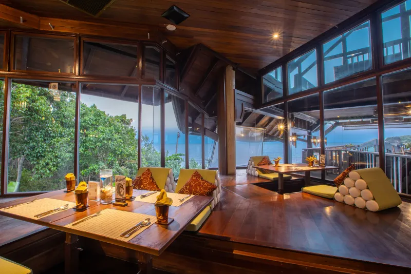 Dining room at Nora Buri Resort with low Thai-style tables and windows over the bay