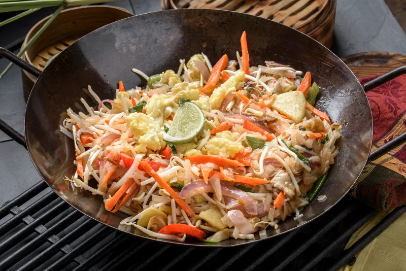 Stir-fried noodles with carrot and lime in a wok from the Outrigger Koh Samui kitchen