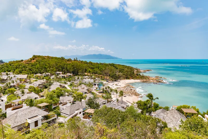 Aerial view of the hillside villas and the rocky private bay of The Ritz-Carlton, Koh Samui, Choeng Mon