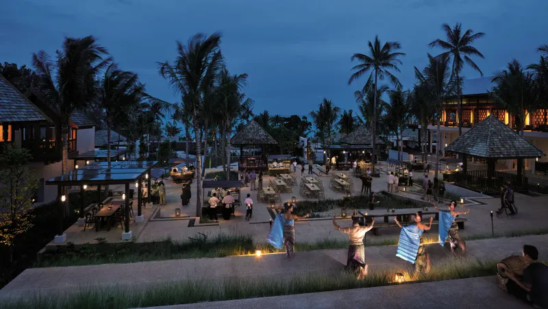Evening dining courtyard with food stalls and a Thai dance performance among palms