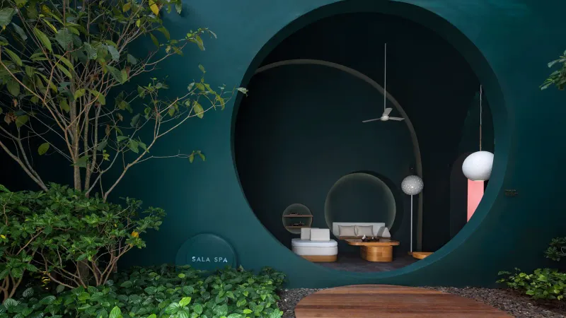 Round window and outdoor soaking area in a teal treatment space at SALA Samui Chaweng spa