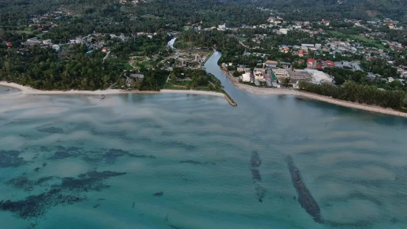 Aerial view of Koh Samui's coastline showing the calm bays families base themselves in