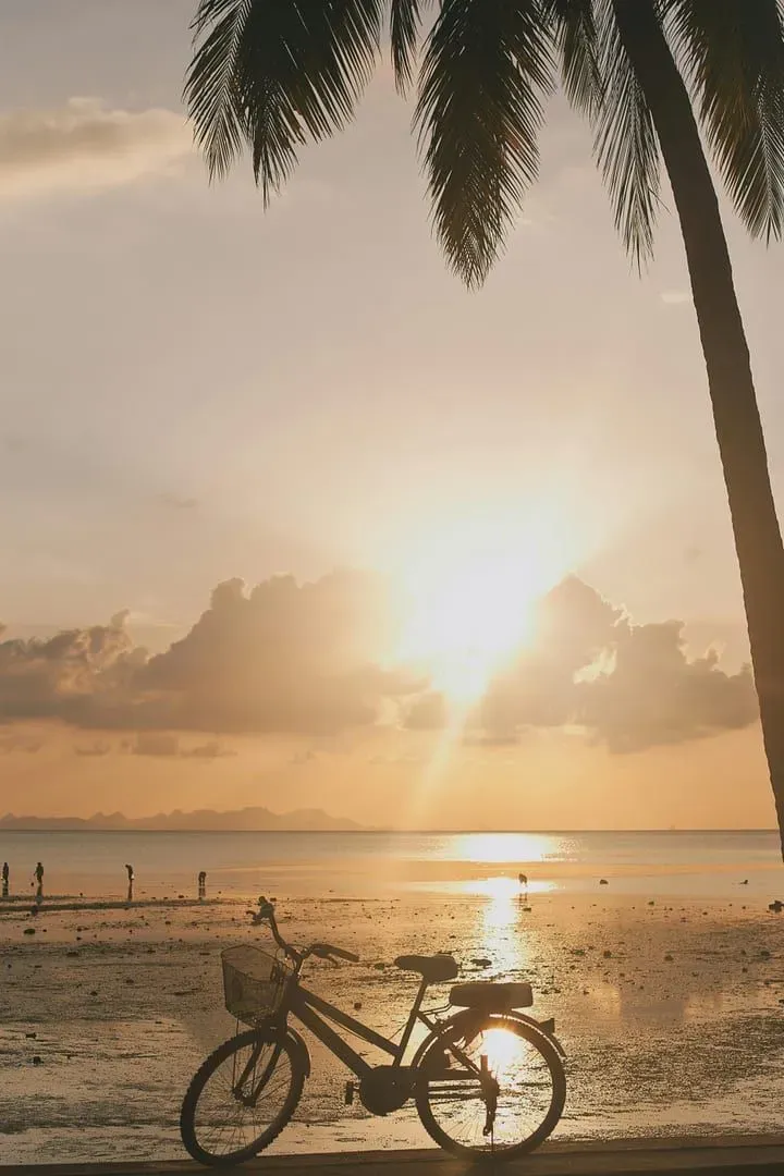 A bicycle parked on the sand at sunset on Lipa Noi's west-facing shore