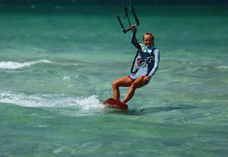 Kiteboarder riding independently across calm water off Koh Samui, the independent-rider stage of IKO progression
