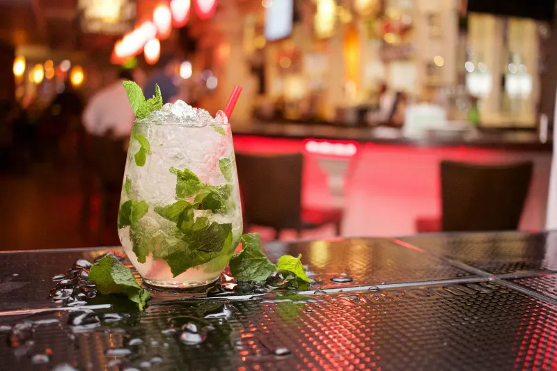 A mojito with mint on a bar counter