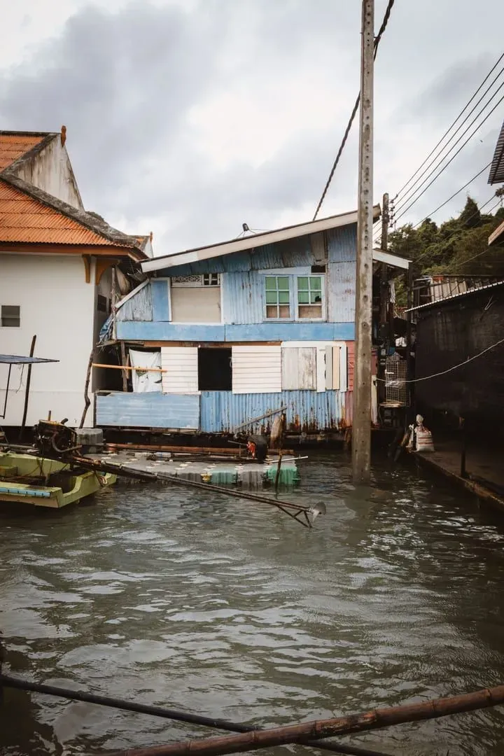 Traditional wooden stilt house beside a canal in southern Thailand