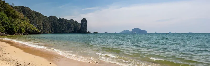 A tropical cliff panorama over turquoise sea, the kind of coastal view the boulder platform looks out on (illustrative)