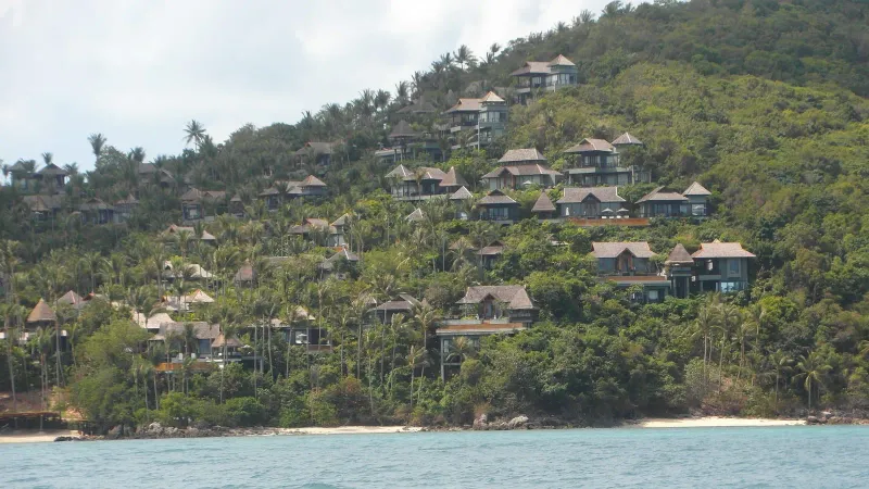 A closer view of resort villas on a forested hillside above Laem Yai Bay, Koh Samui