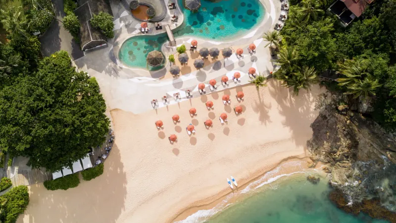 Aerial view of beach umbrellas and pools arranged along Tong Sai Bay's sand