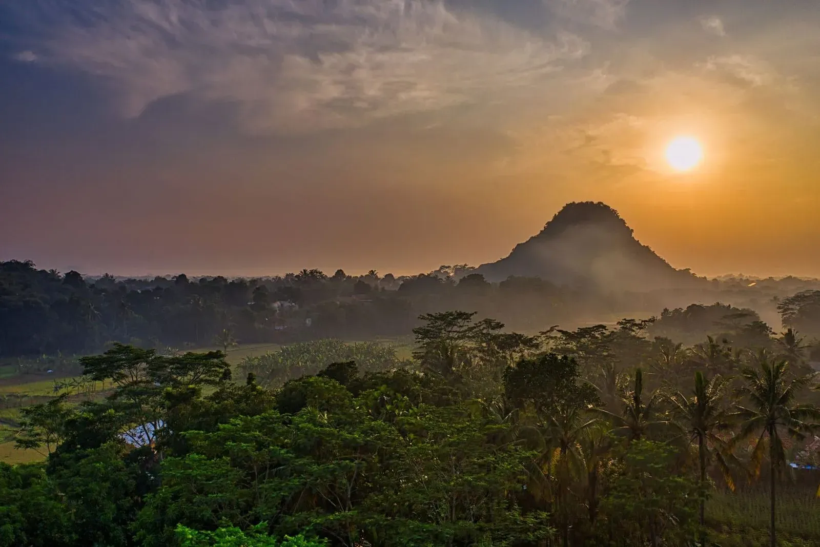 Silhouetted hills and forest canopy against a glowing sunset sky, typical of the ridge-top scenery on the extended valley loop