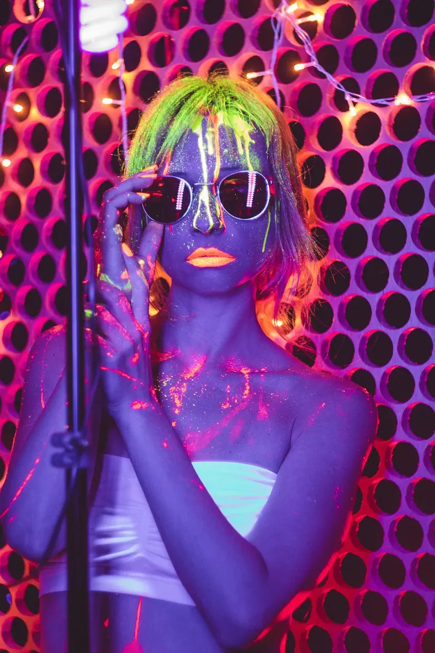 Woman with neon UV face paint and sunglasses